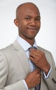 Getting ready for the big meeting. A young african american businessman doing his tie up while isolated on a white Royalty Free Stock Photo