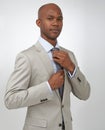 Getting ready for the big meeting. A young african american businessman doing his tie up while isolated on a white Royalty Free Stock Photo