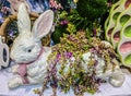 Getting ready for the feast - Ceramic Easter bunny with flowers and greenery and colorful egg dishes Royalty Free Stock Photo