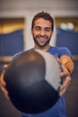 Getting ready for great results. Cropped portrait of a handsome young man working out with a medicine ball in the gym. Royalty Free Stock Photo