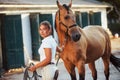 Getting ready for the ride. Horsewoman in white uniform with her horse at farm. Ready for the ride Royalty Free Stock Photo