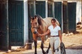 Getting ready for the ride. Horsewoman in white uniform with her horse at farm. Ready for the ride Royalty Free Stock Photo