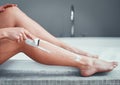 Getting ready for shorts and skirts. Closeup shot of an unrecognizable woman shaving her legs in the bathroom at home. Royalty Free Stock Photo