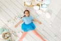 Getting ready to Easter. Lovely little girl holding an Easter egg and smiling with decoration in the background