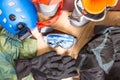 Getting ready for winter vacation. Set of snowboard equipment on the wooden floor. Goggles, snowboard, jacket, boots, gloves Royalty Free Stock Photo