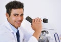 Getting results in the lab. Portrait of a smiling lab technician using a microscope while sitting in a lab. Royalty Free Stock Photo