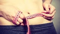 Woman touching stomach holding measuring tape Royalty Free Stock Photo