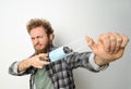 Getting rid of protective medical face mask young handsome man holding it stretching it in front of face wearing plaid Royalty Free Stock Photo