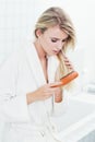 Getting rid of the tangles. A beautiful young woman in her bathrobe brushing her hair.