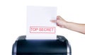 Getting rid of top secret information. Studio shot of a womans hand placing a confidential document into a shredder Royalty Free Stock Photo