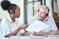 Getting some expert advice. two call centre agents sitting together in the office and having a discussion. Royalty Free Stock Photo