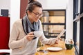 Getting some reading done while enjoying a cup of coffee. an attractive young woman surfing the net in a coffee shop. Royalty Free Stock Photo