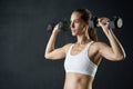 Getting stronger with every lift. Studio shot of an attractive young woman working out with dumbbells against a dark Royalty Free Stock Photo