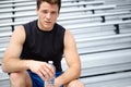 Getting thirsty from all the exercise. Cropped close up portrait of a male runner sitting on the rafters holding a water Royalty Free Stock Photo