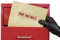 Getting top secret documents from a red file cabinet, over a white background. Royalty Free Stock Photo