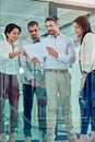 Getting work done, together. a group of coworkers talking over some paperwork in an office. Royalty Free Stock Photo