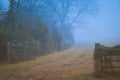 Gettysburg, PA / USA - December, 2018: An old wooden fence along the mystical dirt road in the fog. Autumn concept Royalty Free Stock Photo