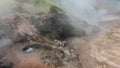 Geyser cauldron on the hillside. The water is boiling.