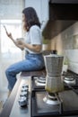 geyser coffee kettle on the cook top at the kitchen woman drinking on background