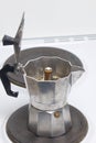 A geyser coffee machine is on the electric stove. It is visible as ready coffee under pressure pours out in the container.