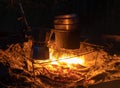 A geyser coffee machine near the fire. Picnic in nature. Camping in the mountains. Night coffee in the forest