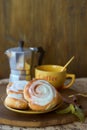 Geyser coffee maker and cinnamon bun on a wooden tray. With coffee cup and spoon. Dark background