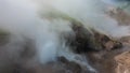 A geyser erupts on the hillside.