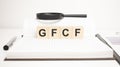 GFCF word concept. wooden cubes, notepad, pen and business charts