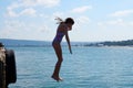 Girl dives into the sea against the horizon