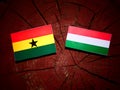 Ghanaian flag with Hungarian flag on a tree stump isolated