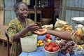 Ghanaian market woman sells vegetables and herbs