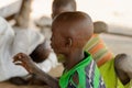 Unidentified Ghanaian boy in green shirt raises his hand in the