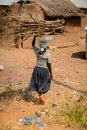 Unidentified Ghanaian woman carries wood over her head in a loc