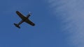 Retro propeller training airplane of 1940s in flight in blue sky. Copy space
