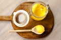 Ghee clarified butter desi in glass jar with spoon made from wood on natural wooden background Royalty Free Stock Photo
