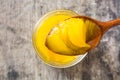 Ghee or clarified butter in jar and wooden spoon on wooden table.