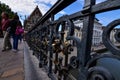 Ghent, Belgium, August 2019. Detail of the padlocks on the railings of the St. Michael bridge. People walking on the bridge, in