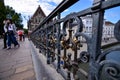 Ghent, Belgium, August 2019. Detail of the padlocks on the railings of the St. Michael bridge. People walking on the bridge, in