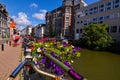 Ghent, Belgium, August 2019. Planters with brightly colored plants and some parked bikes stand out along the canals. People walk