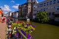 Ghent, Belgium, August 2019. Planters with brightly colored plants and some parked bikes stand out along the canals. People walk