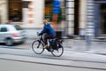 Ghent, Belgium; 10/31/2018: Panning effect photography of a woman riding on a bike through a street in the city