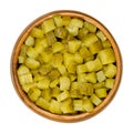 Pickled cucumber, diced, also known as pickle or gherkin, in wooden bowl