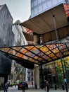 Gherkins building bullet like behind a moderns building with colourful roof and people walking on the street Royalty Free Stock Photo