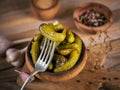 Gherkins, pickled cucumber on a fork, bowl of marinated vegetables on a rustic wooden background. Clean eating, vegetarian food Royalty Free Stock Photo