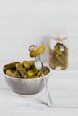 Gherkins, pickled cucumber on a fork, bowl of marinated vegetables Royalty Free Stock Photo