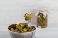 Gherkins, pickled cucumber on a fork, bowl of marinated vegetables Royalty Free Stock Photo