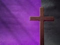 Lent Season, Holy Week, Good Friday, Easter Sunday Concept. Close up of wooden cross in purple black background with copy space. Royalty Free Stock Photo