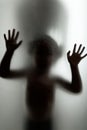 Ghost concept shadow of a child behind the matte glass blurry hand Royalty Free Stock Photo