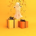 Ghost, confetti and gift box on orange background, copy space text area. Design creative concept of happy halloween celebration ho