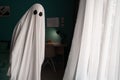Ghost covered with a white ghost sheet on a bedroom. Halloween Concept
